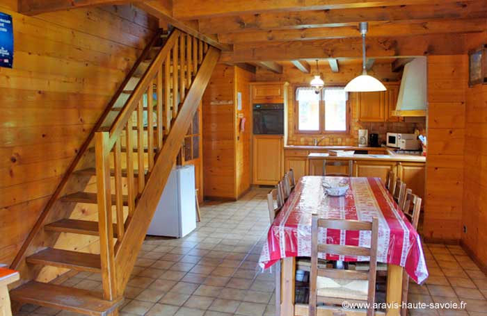 Salon avec cuisine américaine chalet San Parfia cuisine entièrement équipée, cuisinière, micro ondes, lave vaisselle, appareil à raclette